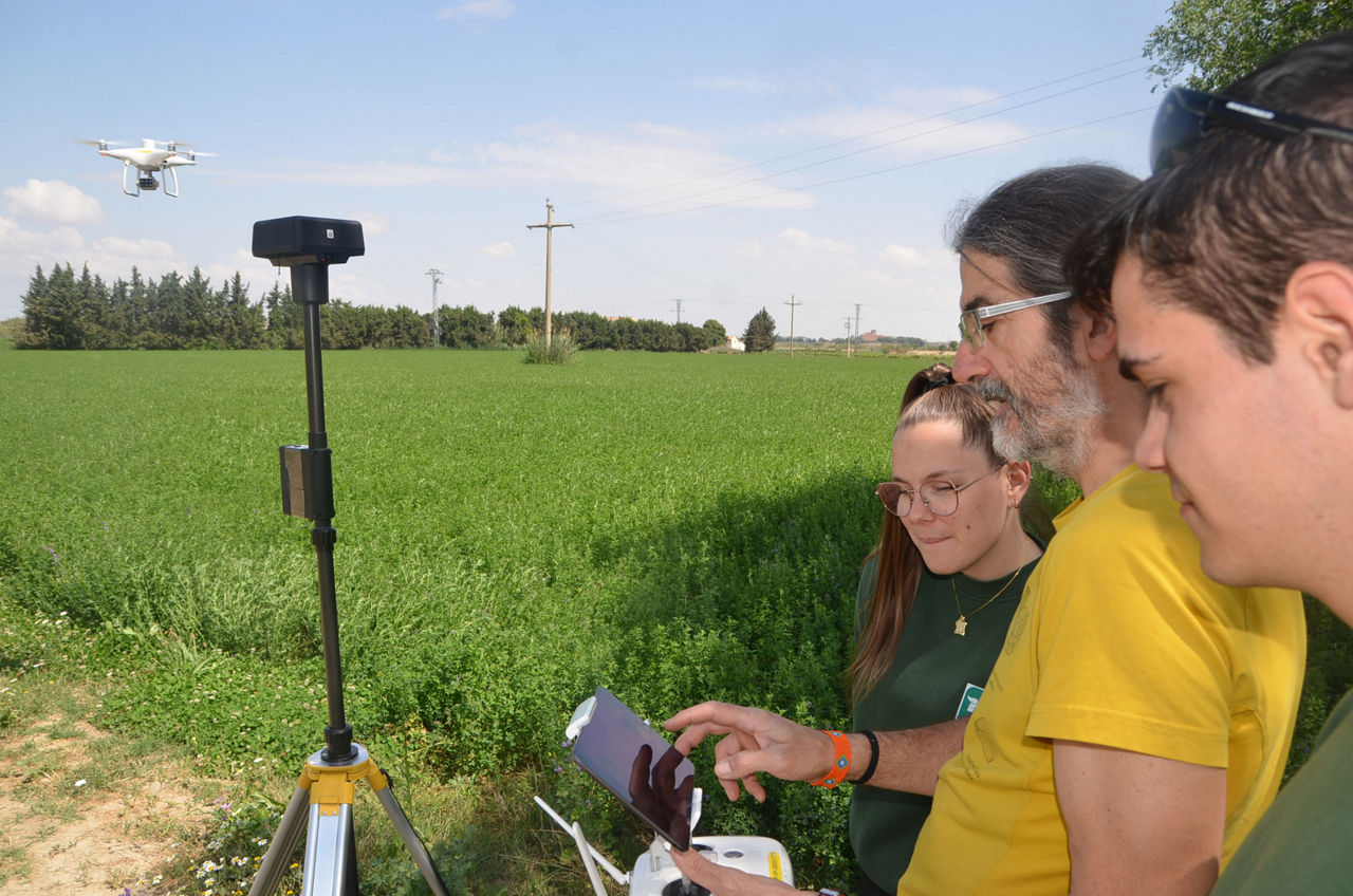 El profesor Jorge Andrés y dos alumnos, vigilando el vuelo de un dron en el campo. 