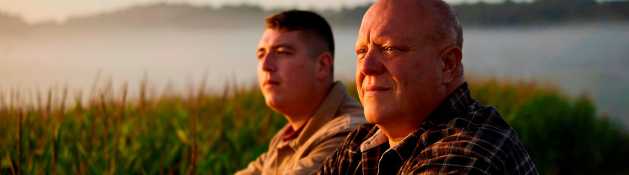 Father and Son farmers in field at dawn