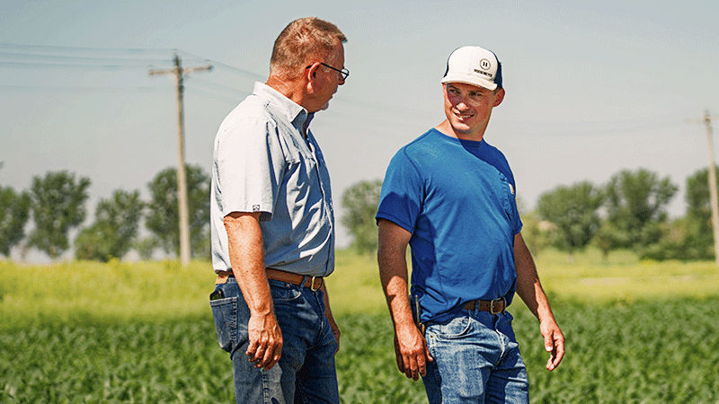 Farmer and rep walking mext to a field