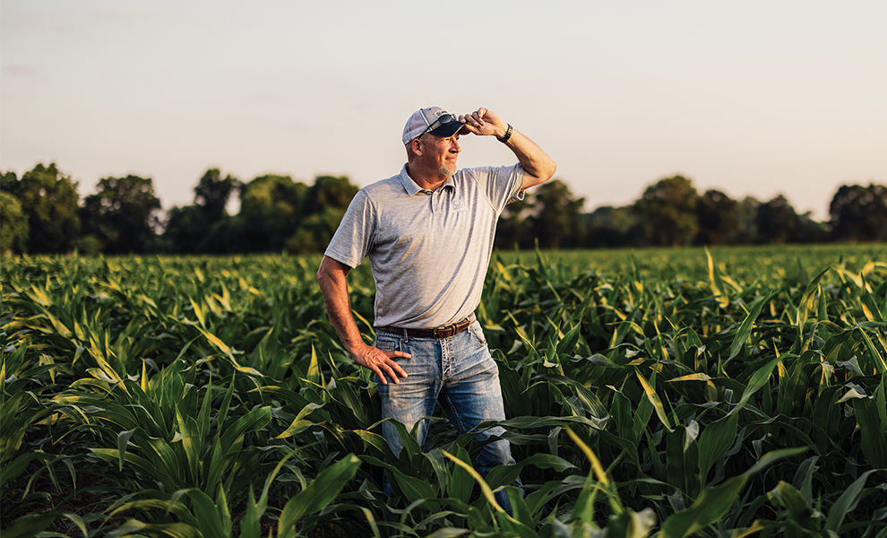 Travis standing in corn field at sunset