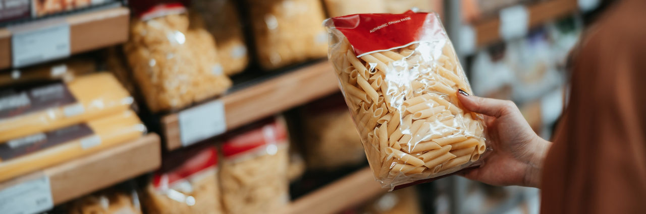 selecting pasta and a grocery store