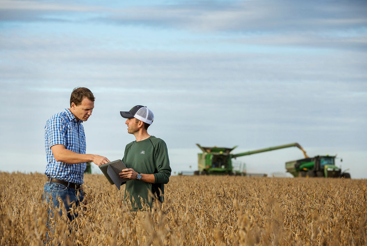 Un Tecnico Pioneer con un agricoltore in un campo di soia